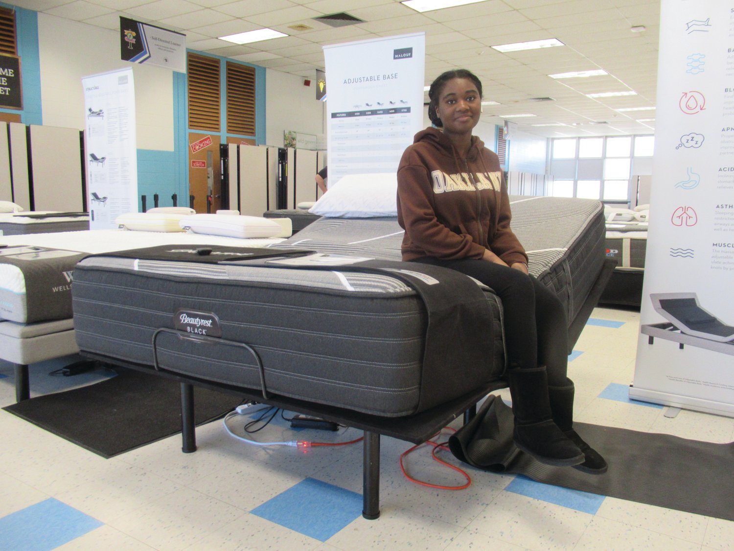 SPECIAL SEAT: Makaila Fosu, 15, a sophomore at Johnston High School and talented alto singer with various JHS choruses, enjoys a lighter moment during Saturday’s mattress sale.